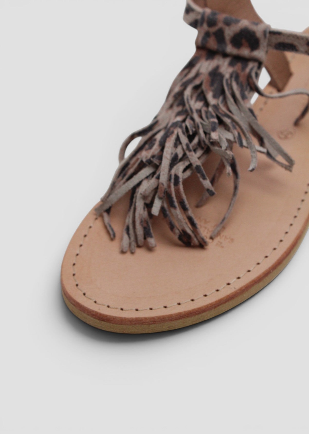 ARIEL – SANDALO INFRADITO IN SUEDE STAMPA MACULATA CON FRANGE E CINTURINO ALLA CAVIGLIA